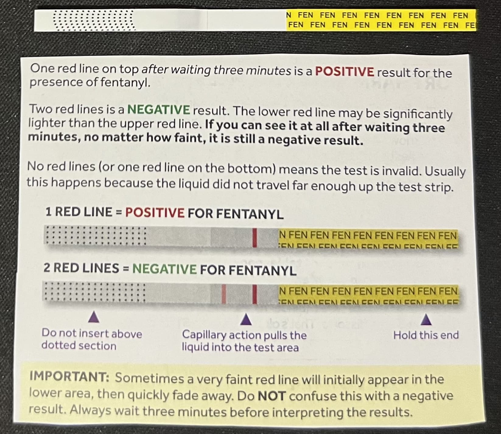 A real fentanyl test strip photographed above its instruction card, showing that one red line means positive and two red lines means negative